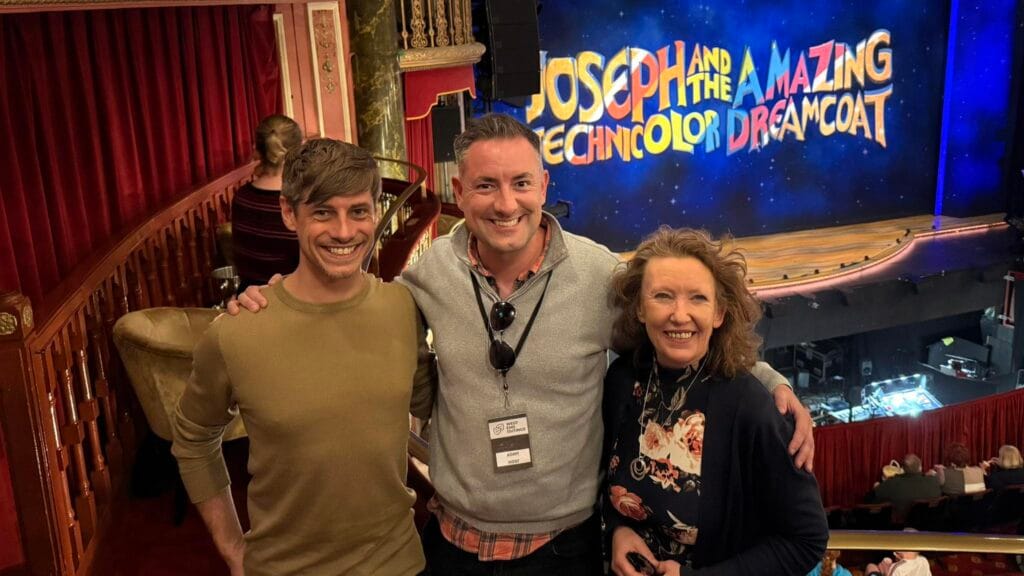 Members posing by a West End show's stage set at a London theatre social club outing