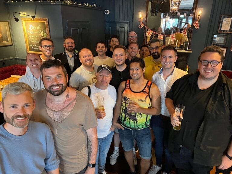 Friends having drinks at a gay theatre night social in a London bar