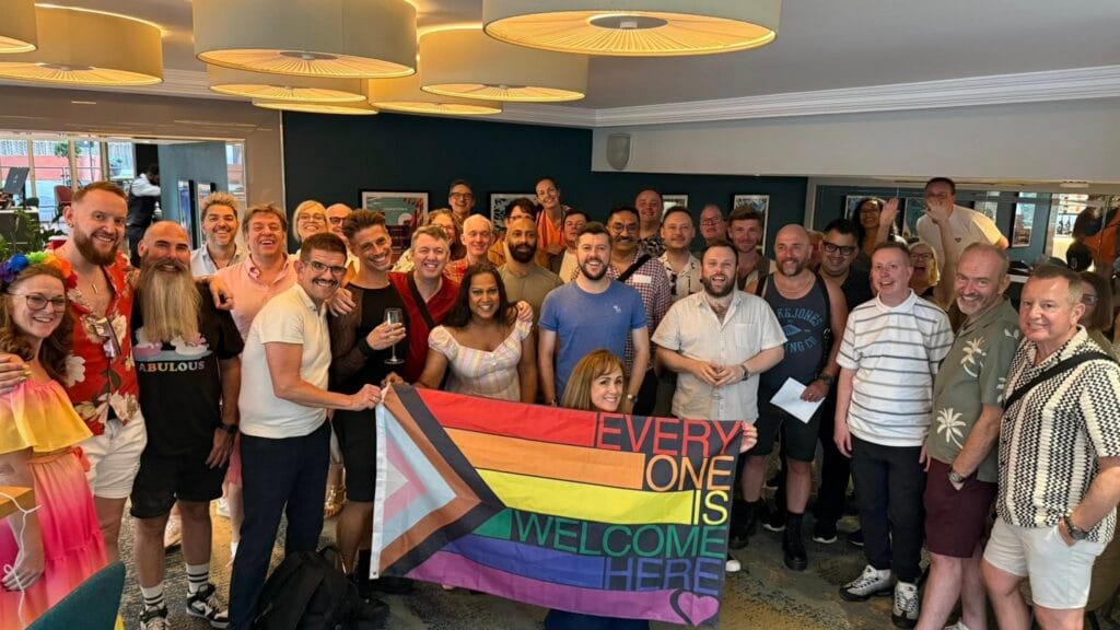 West End Outings members holding a Progress Pride flag at an LGBTQ+ theatre event in London